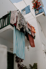 Picturesque narrow blue and white cobble street and traditional Greek houses in Mykonos Island,...
