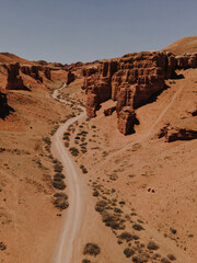 Fototapeta premium Canyon valley with red rocks. Panoramic view to the road in the red canyon. Hiking the canyon. 