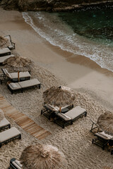 Relaxing scene at a holiday lounge deck by the sea overlooking blue waves and ocean, sun reflecting...