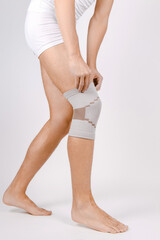 Knee Support Brace on leg isolated on white background. Elastic orthopedic orthosis. Anatomic...