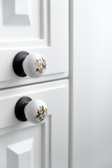 Extremely close-up detail of vintage white cabinet, original ceramic handles, selective focus, copy space