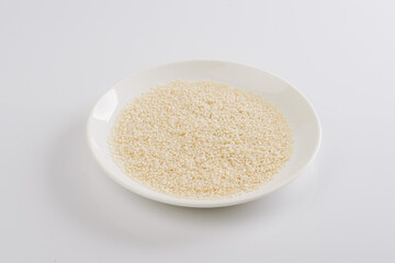 white sesame seeds on a white plate on a white background