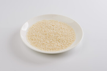 white sesame seeds on a white plate on a white background