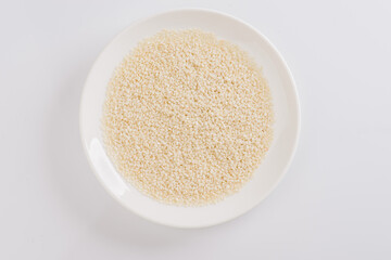 white sesame seeds on a white plate on a white background