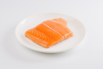 raw salmon fillet on a white plate on a white background - Powered by Adobe