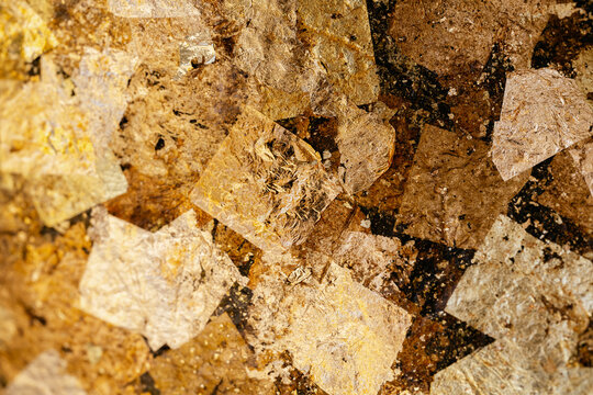 Closeup of gold leaf that people attach to surface of Buddha statue according to Buddhism beliefs. Texture background.
