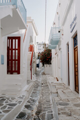 Picturesque narrow blue and white cobble street and traditional Greek houses in Mykonos Island, Greece