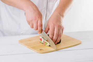 the chef prepares sushi and cuts them with a knife