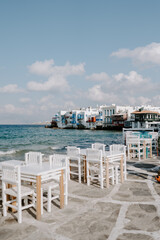 Picturesque narrow blue and white cobble street and traditional Greek houses in Mykonos Island, Greece