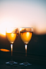 champagne glasses are on the windowsill against the sunset