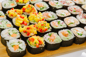 Maki Sushi Rolls set on wooden board. Japanese traditional Cuisine. White background.