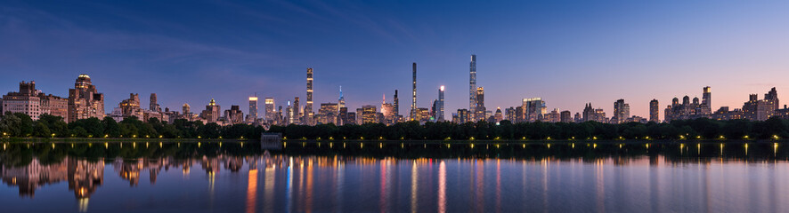 Panoramic New York City skyline. Midtown Manhattan skyscrapers from Central Park Reservoir at Dusk....