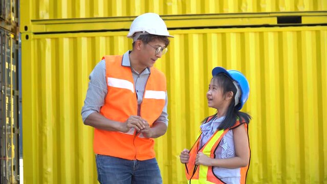 asian Foreman talking with girl on  Containers box at warehouse logistic in Cargo . father and  cute little daughter teaching occupation in workplace