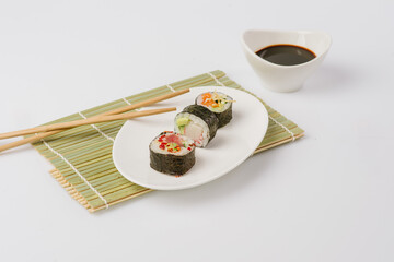 Fototapeta na wymiar Maki Sushi Rolls set on wooden board. Japanese traditional Cuisine. White background.