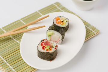 Maki Sushi Rolls set on wooden board. Japanese traditional Cuisine. White background.