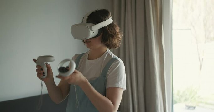 Woman in VR goggles playing game at home