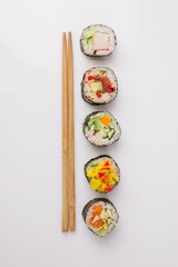 Maki Sushi Rolls set on wooden board. Japanese traditional Cuisine. White background.