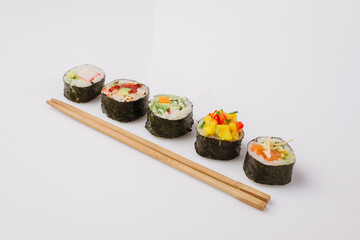 Maki Sushi Rolls set on wooden board. Japanese traditional Cuisine. White background.
