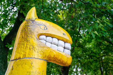 The statue. A strange cartoon statue of a yellow horse with large teeth and a mouth