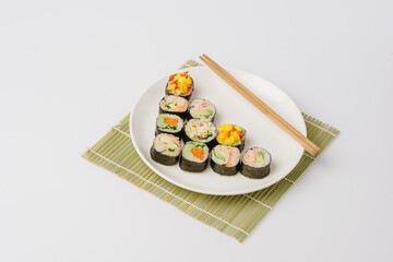 Maki Sushi Rolls set on wooden board. Japanese traditional Cuisine. White background.
