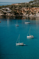 A tranquil scene of beautiful landscape in Ibiza overlooking turquoise waters and white sand beach. 