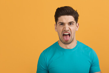 Young caucasian man on orange background in studio