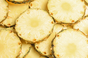 Pineapple juicy yellow slices background. Top view.