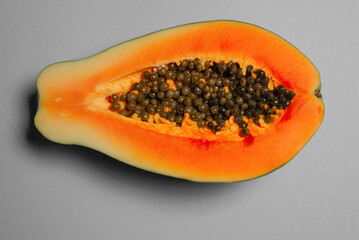 Papaya fruit on a grey background in woman hands. Tropical fruit.