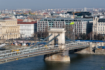 Obraz premium Cityscape of budapest with Szechenyi chain bridge over Danube river under renovation