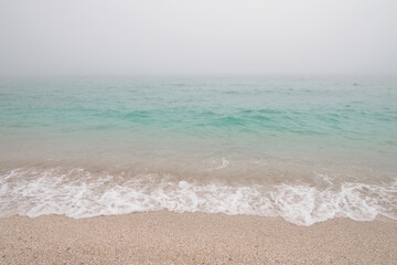 Fototapeta na wymiar Blue azure sea and wave in white fog (haze) as background
