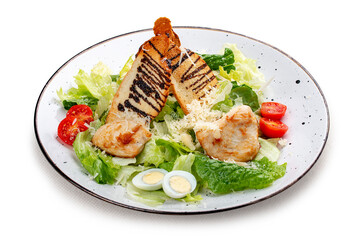 Caesar salad with chicken on a white decorative plate. A classic salad.