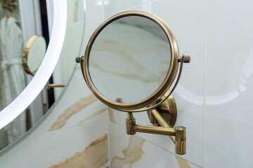Round magnifying cosmetic wall mirror for the bath.