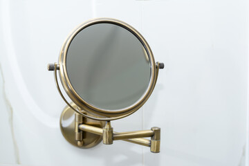 Round magnifying cosmetic wall mirror for the bath.
