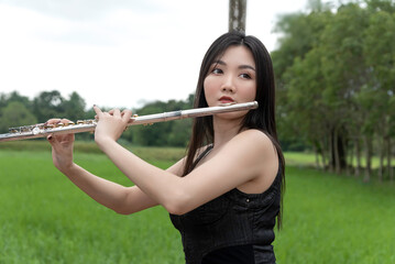 woman playing flute in nature show music concept. © montira