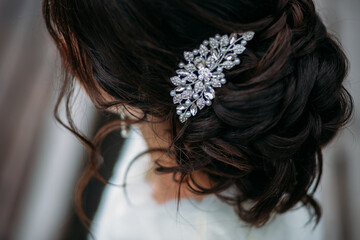 woman's crystal hairpin on the bride's wedding hairstyle with dark hair. hairstyle like a loose...