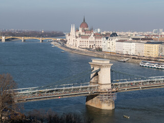 Fototapeta na wymiar Szechenyi chain bridge across Danube river under renovation and parliament building in Budapest, Hungary