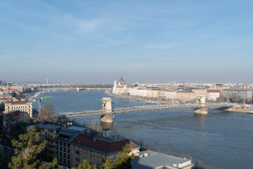 Fototapeta premium Szechenyi chain bridge across Danube river under renovation and parliament building in Budapest, Hungary
