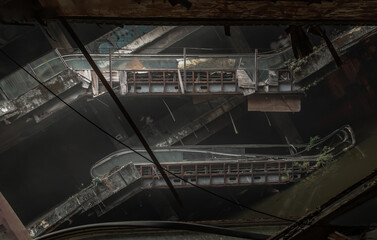 Fototapeta na wymiar Bangkok, Thailand - 07 Feb 2022 : Damaged escalators in abandoned shopping mall building. Structural and ruins was left to deteriorate over time, New World Mall, Selective focus.