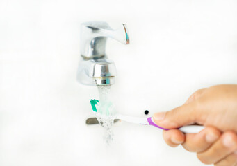 closeup daily cleaning of the toothbrush after use in basin