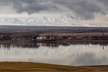 amazing mountains under grey clouds and reflection in mountain lake