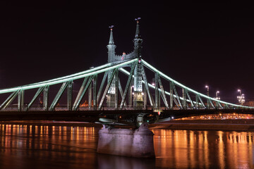Liberty Bridge across Danube river illuminated at night in Budapest, Hungary
