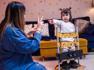 Mother playing with daughter in standing frame