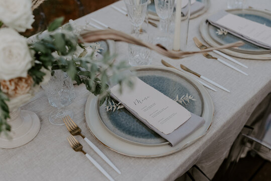 Elegant destination wedding table setting featuring a neutral color palette fine tableware floral arrangements and personalized menus. A perfect image for luxury events, receptions, and celebrations
