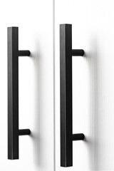 white wood cupboard door by black handle. Modern kitchen furniture concept. Cozy apartment details