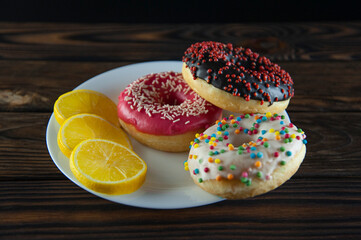 Colored donuts on a white plate with lemon.