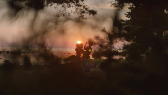 Cinematic and romantic shot of beautiful couple do interpretative dance on sunset. Conceptual love story in outdoor setting on beach. Mindful relationship and sensual tender feelings