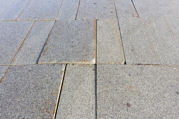 Obraz premium The pedestrian road paved with paving slabs was badly damaged.