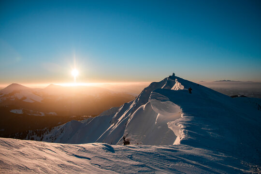 Awesome view of picturesque landscape and snow-covered mountain top and skiers on it. Ski touring concept