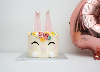 Trendy cake for children's Birthday party or Ester. Cheerful bunny with a muzzle and ears.