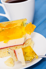 Homemade creamy fruit cake with jelly and cup of coffee. Delicious dessert for different occasions